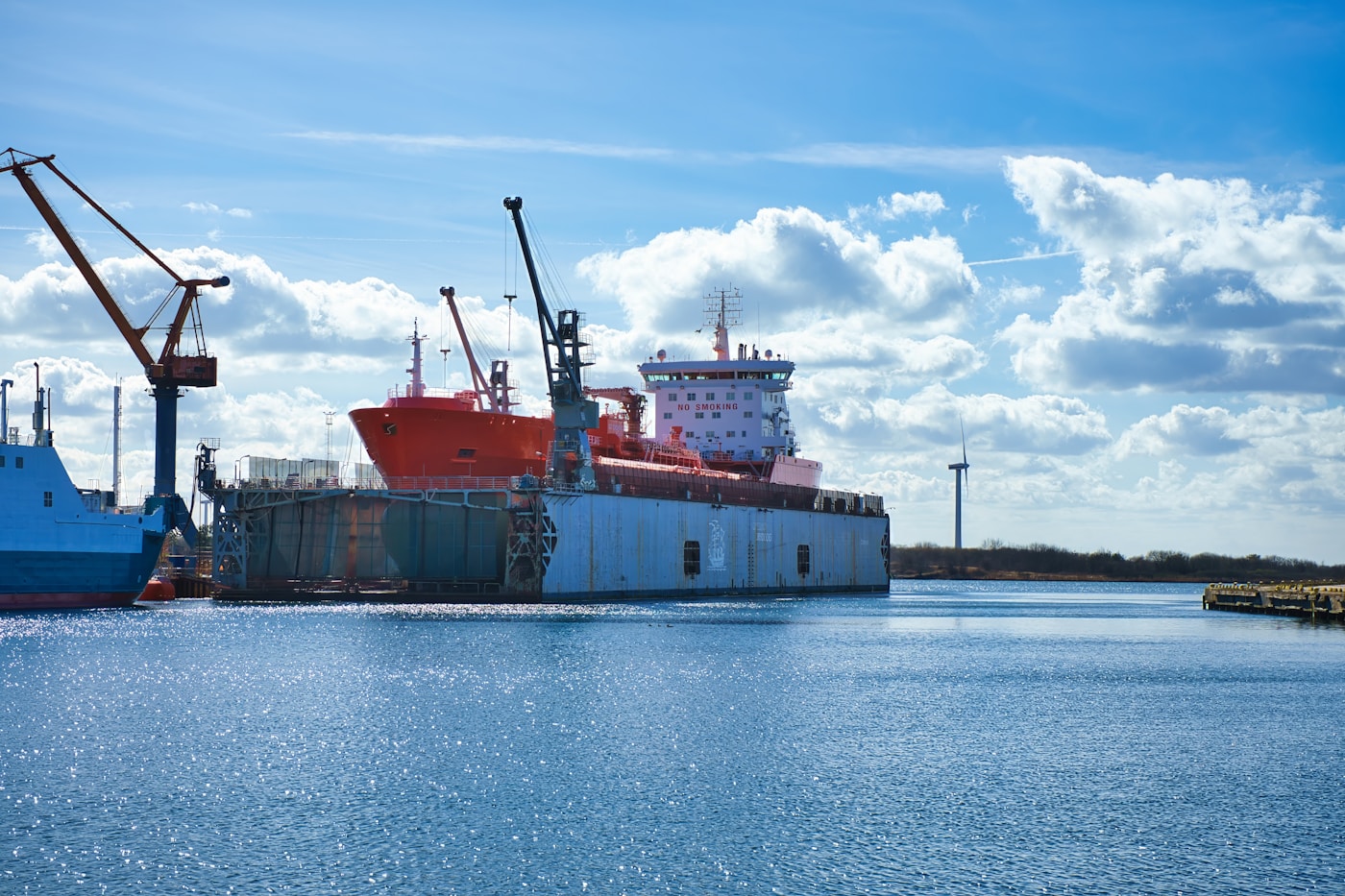 Large cargo ship at an industrial harbor and shipyard